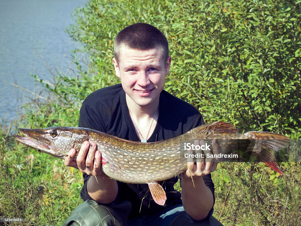 Man holding a pike in his hands A man shows his catch Catching Stock Photo