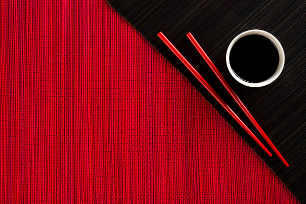 istock Chopsticks and bowl with soy sauce on bamboo mat 523015519