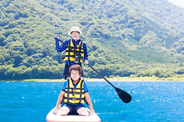 Asian mother and her son on the Stand up paddle board.