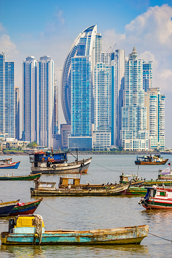 Cityscape photo of fishing boats and the skyline of Panama City with condo apartment buildings in the background in the Republic of Panama.