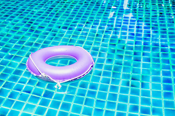 istock pink floating ring on blue water swimpool with waves reflecting 523034336