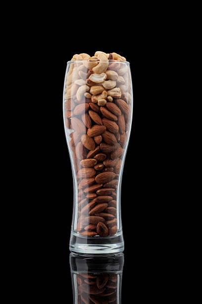 пиво и закуски. миндаль и кешью. - cashew beer nuts nut food стоковые фото и изображения