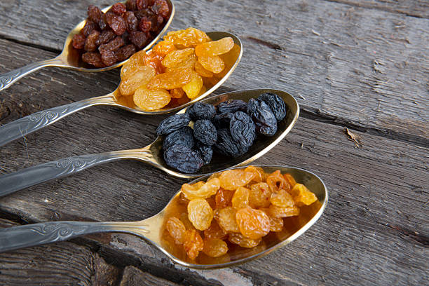 istock raisins in metal spoons on wooden table 523035740