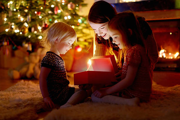 madre y sus hijas que s'un regalo de navidad - home decorating living room luxury fireplace fotografías e imágenes de stock
