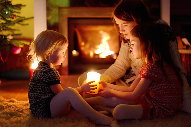 familia feliz junto a una chimenea en navidad - home decorating living room luxury fireplace fotografías e imágenes de stock