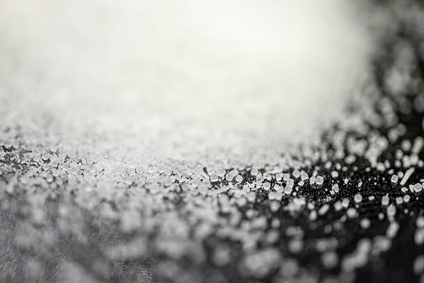 macro detalle de azúcar crystal flor sobre un fondo negro. - salt crystal spoon food fotografías e imágenes de stock