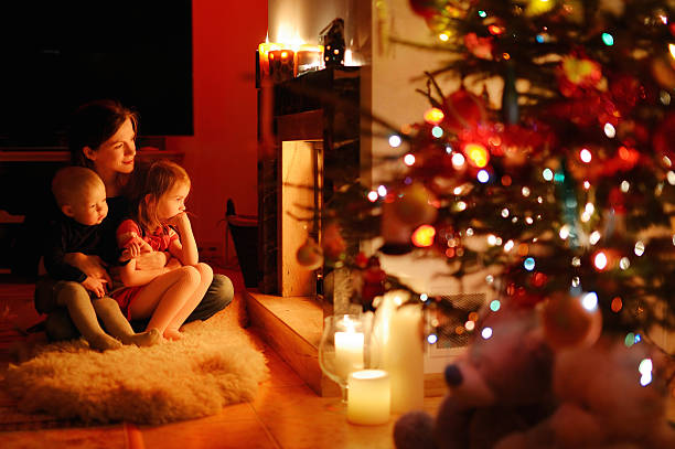 istock Young mother and her daughters by a fireplace 523037119