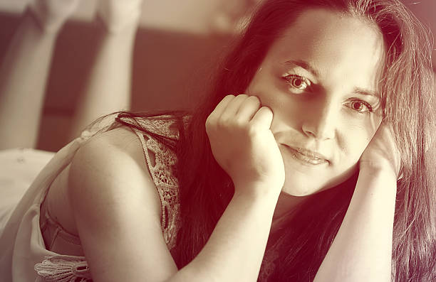 istock Young woman posing on a bed 523037504