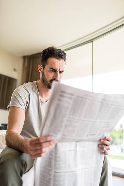 istock man reading the newspaper on bedroom 523038394