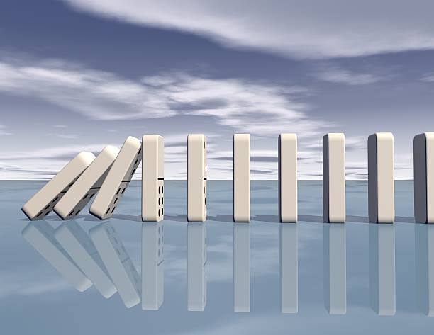 istock dominoes falling with blue sky blue background 523038887