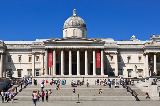 London, United Kingdom - June 30, 2015: Trafalgar Square with National Gallery, London, England. Tourists and vivid blue clear sky are in the image.