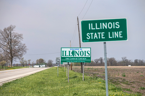 Welcome to Illinois sign along U.S. Route 36 at the Illinois/Indiana state line.  Focus is on larger sign in the middle of the image.