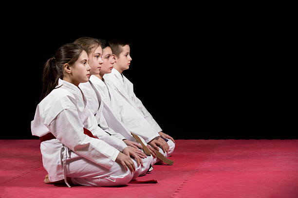 enfants en kimono assis sur un tatami. - child sport karate education photos et images de collection