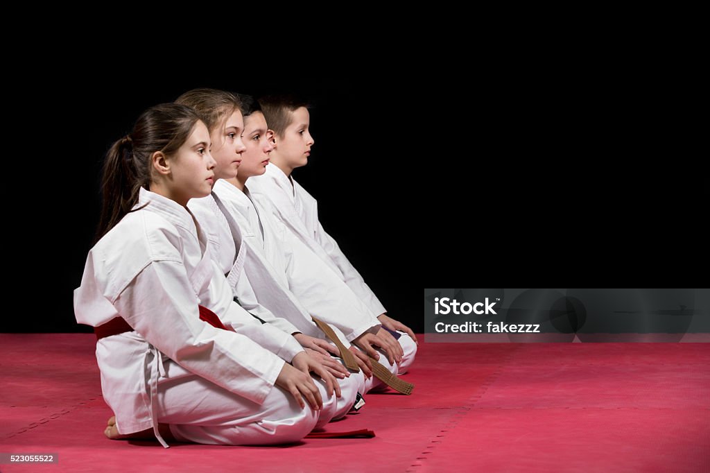 Children in kimono sitting on tatami. Children in kimono sitting on tatami on martial arts seminar. Selective focus. Child Stock Photo