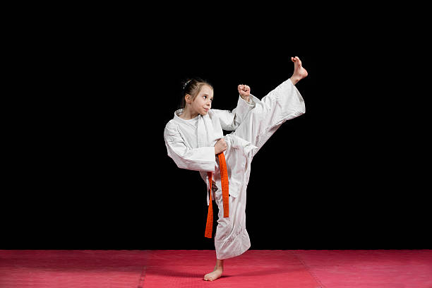 istock Little girl practice karate isolated on black 523056462