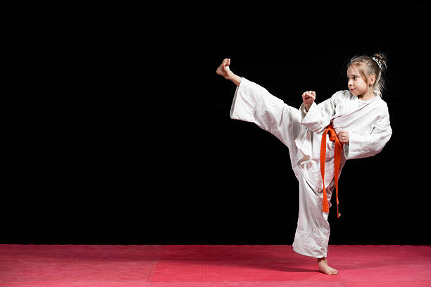 istock Little girl practice karate isolated on black 523056492