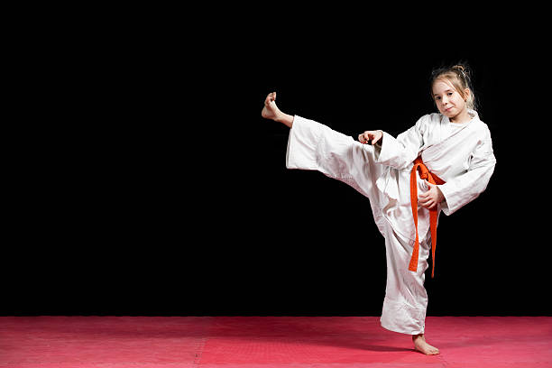 istock Little girl practice karate isolated on black 523056518