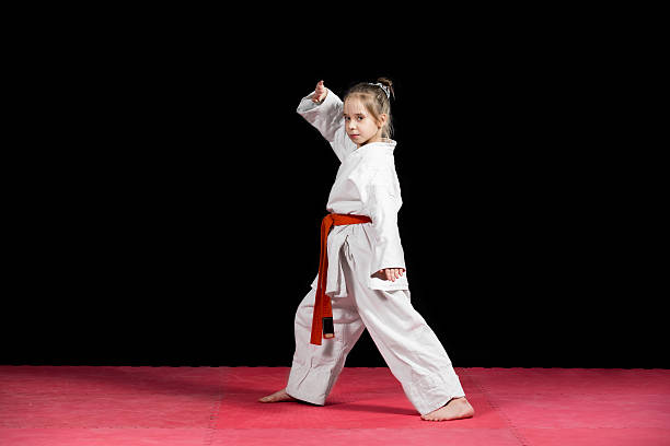 istock Little girl practice karate isolated on black 523056544