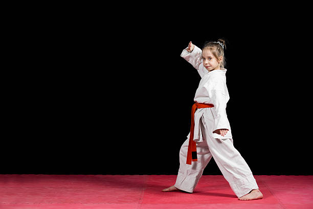 istock Little girl practice karate isolated on black 523056558