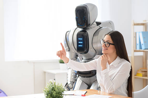 istock Pleasant girl sitting in the office with robot 523058746