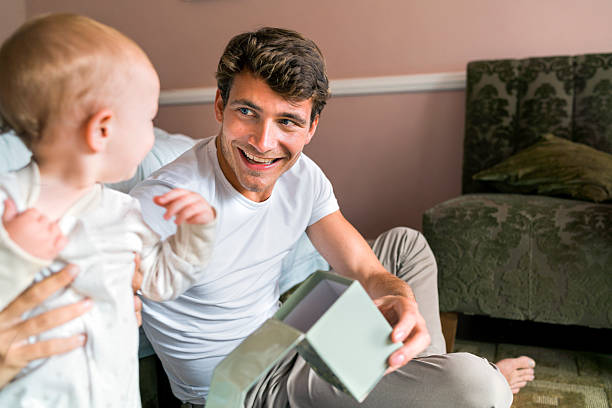 istock Happy father holding box while looking at baby at home 523059414