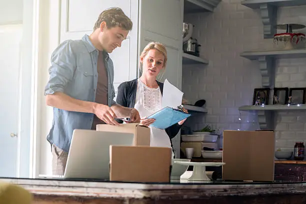 Photo of Young couple wrapping Christmas presents at home