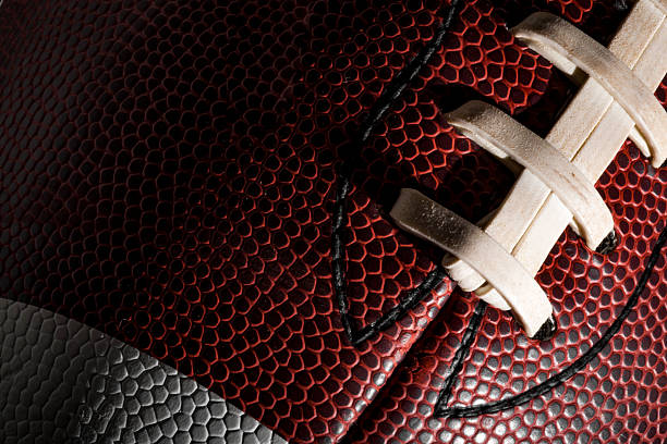 Macro of an american football ball Macro of an american football ball with visible laces, stitches and pigskin pattern american football sport stock pictures, royalty-free photos & images