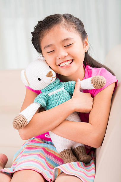 I love you so Cute Asian little girl embracing tight her favorite toy vietnamese girls for sale stock pictures, royalty-free photos & images