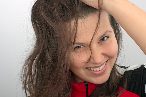 Close view of smiling girl's face and a hand tousling a hair