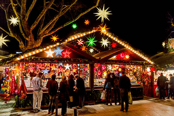 Shopping for Stars Stuttgart, Germany - December 21, 2013 - People shop at a stall selling decorative stars at the Christmas market at night on December 21, 2013 in Stuttgart. stuttgart photos stock pictures, royalty-free photos & images