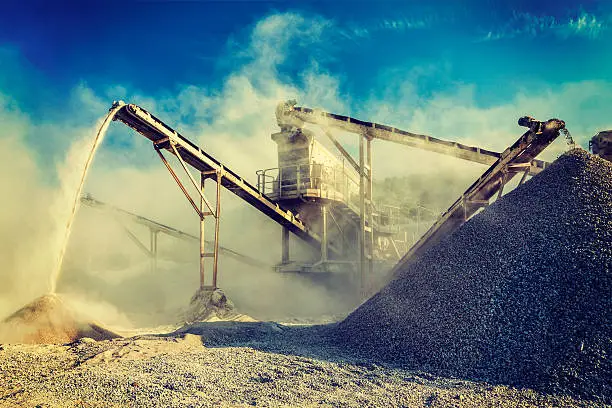 Vintage retro effect filtered hipster style image of Industrial background - crusher rock stone crushing machine at open pit mining and processing plant for crushed stone, sand and gravel