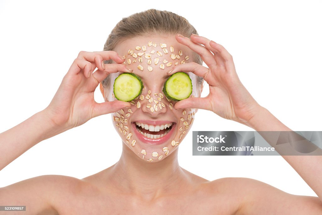 Happy young woman making oatmeal mask with cucumber Happy young woman with making oatmeal mask with cucumber Facial Mask - Beauty Product Stock Photo