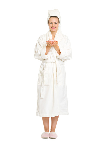 Full length portrait of young woman in bathrobe holding cup of coffee
