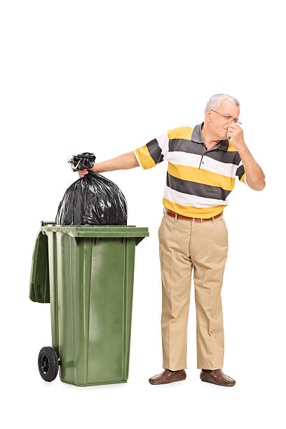 istock Senior throwing away a stinky bag of trash 523115719