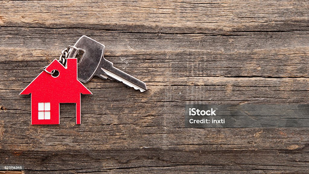 Symbol of the house with silver key Symbol of the house with silver key on vintage wooden background Abstract Stock Photo