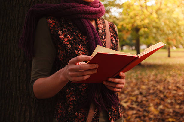giovane donna leggendo nel parco - autumn women leaf scarf foto e immagini stock