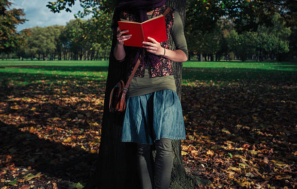 istock Young woman reading in the park 523116715