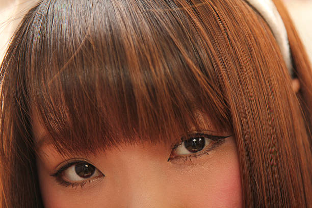 Close up of the eyes and hair bangs of a young Asian woman.