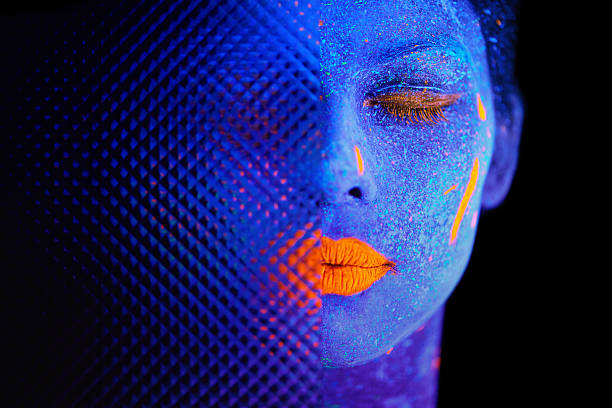 This is your time to shine Shot of a young  woman posing with neon paint on her face fluorescent photos stock pictures, royalty-free photos & images