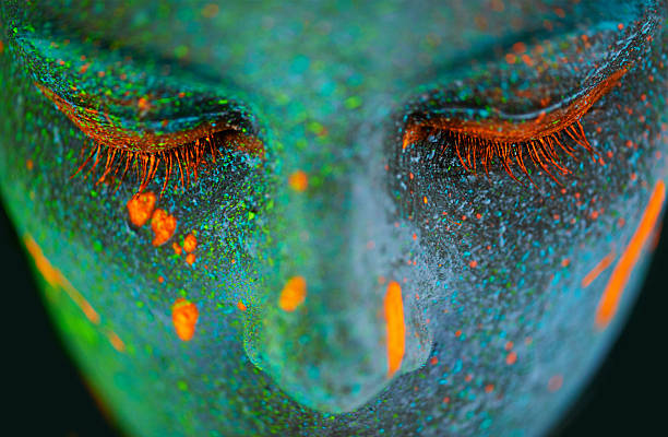 Her beauty glows in the dark Shot of a young woman posing with neon paint on her facehttp://195.154.178.81/DATA/shoots/ic_784268.jpg creepy glowing eyes stock pictures, royalty-free photos & images