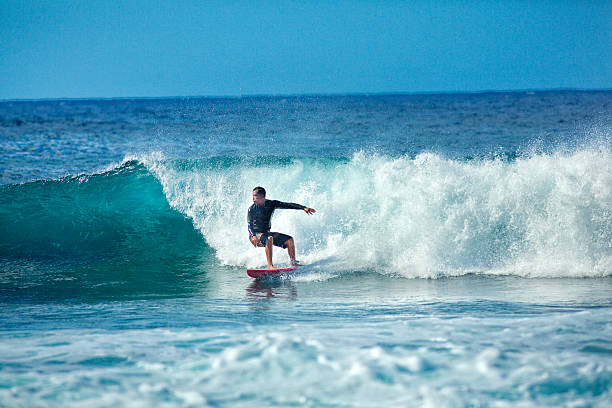 hawaii surfer surf le onde della spiaggia sull'isola di kauai - big wave surfing foto e immagini stock