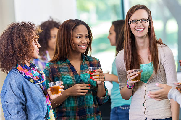 college filles parlant lors d'une fête ou un événement de mixage au club d'étudiantes - club détudiantes photos et images de collection