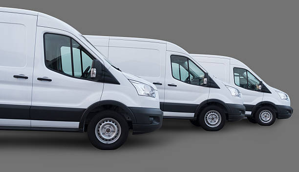 drei weiße lieferung kleinbusse auf grauem hintergrund. - moving van moving office moving house truck stock-fotos und bilder
