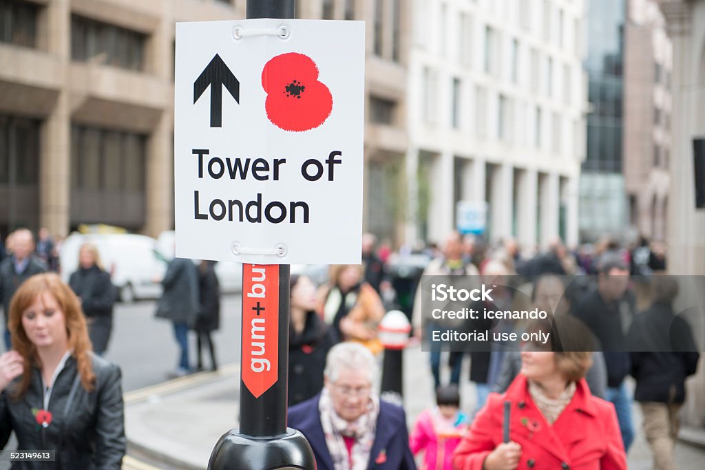 Blood Swept Lands and Seas of Red London, UK - November 8, 2014: Street sign with red poppy pointing to the Tower of London. The ceramic poppies installation was created to mark the centenary of WWI's outbreak. Armed Forces Stock Photo