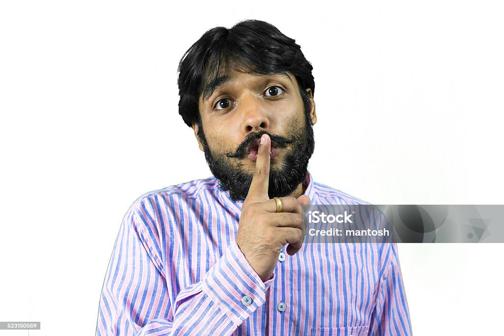 Shhhh! Young man in beard asking to keep quite Finger on Lips Stock Photo