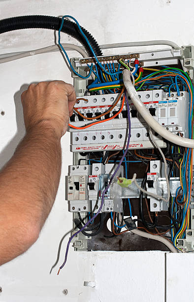 istock Electrician connects cable to the power box 523150593