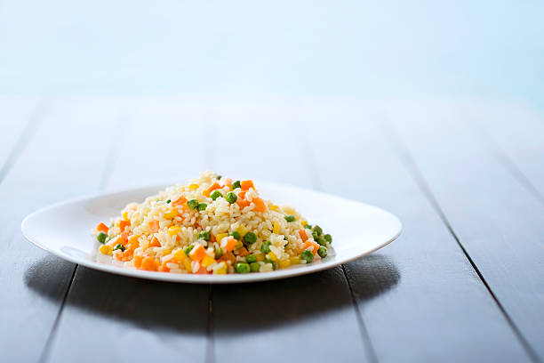 Pilaf Rice with Vegetables on a Plate by the Sea Cooked Pilaf Rice with Vegetables on a Plate by the Sea. fried rice stock pictures, royalty-free photos & images