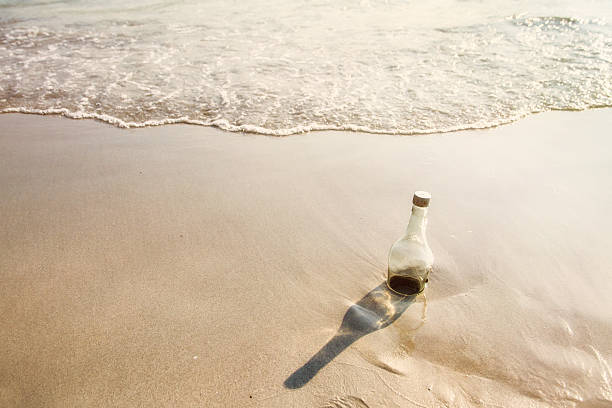 istock Empty glass bottle washed up as rubbish on a beach, 523163066