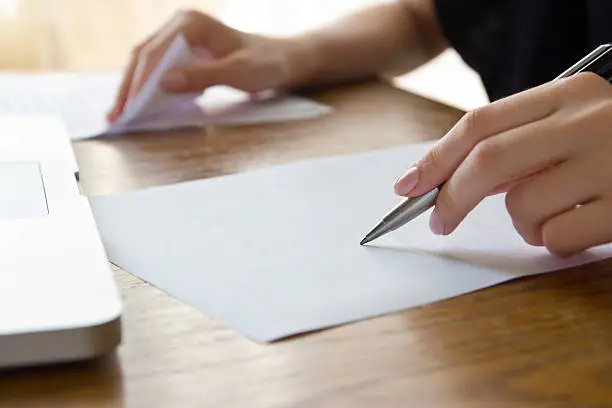 woman working with text using paper and laptop