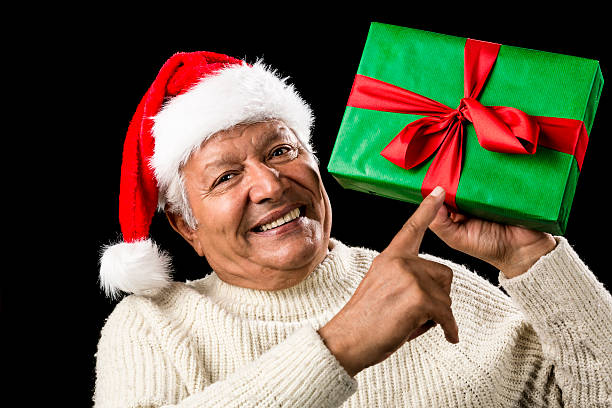 istock Old Man With Gentle Smile Pointing At Green Gift 523166221